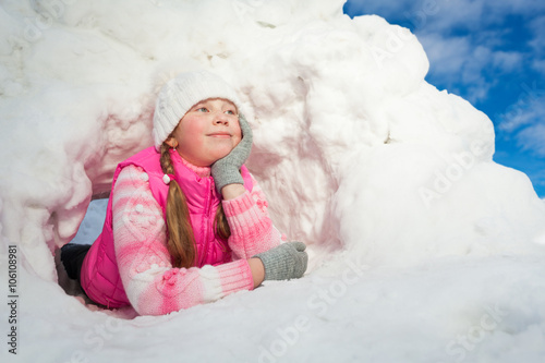 Thoughtful girl laying at the snow hole photo