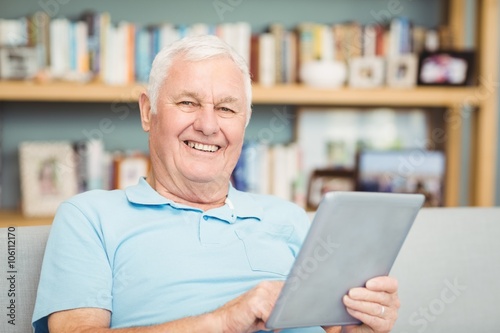 Portrait of smiling senior man using digital tablet