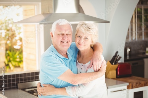 Portrait of senior couple embracing in kitchen