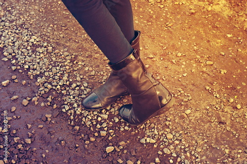 feet in boots on a stone road, retro toning