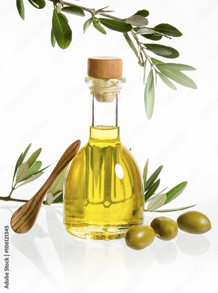 Olivenölflasche mit Olivenzweig, Oliven und Holzlöffel Olivenölflasche mit Olivenzweig, Oliven und Holzlöffel