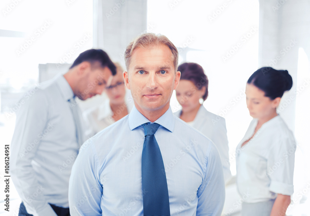 businessman in office with group on the back businessman in office with group on the back