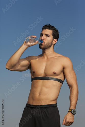 running photo of man with heartbeat meter drinking water.selecti