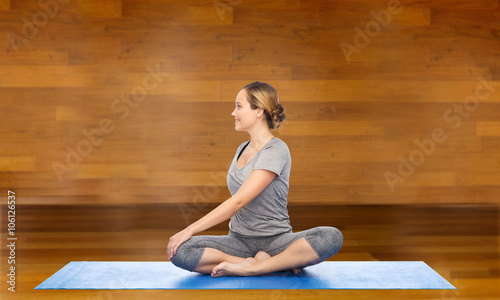 woman making yoga in twist pose on mat