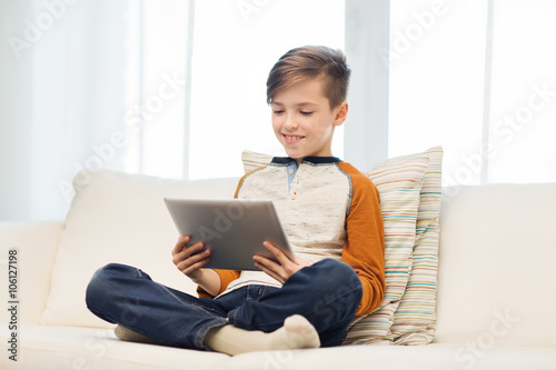 smiling boy with tablet computer at home