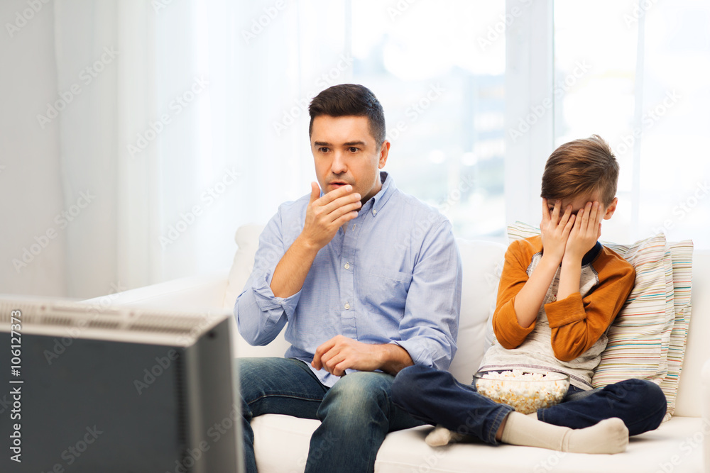 father and son watching horror movie on tv at home father and son watching horror movie on tv at home