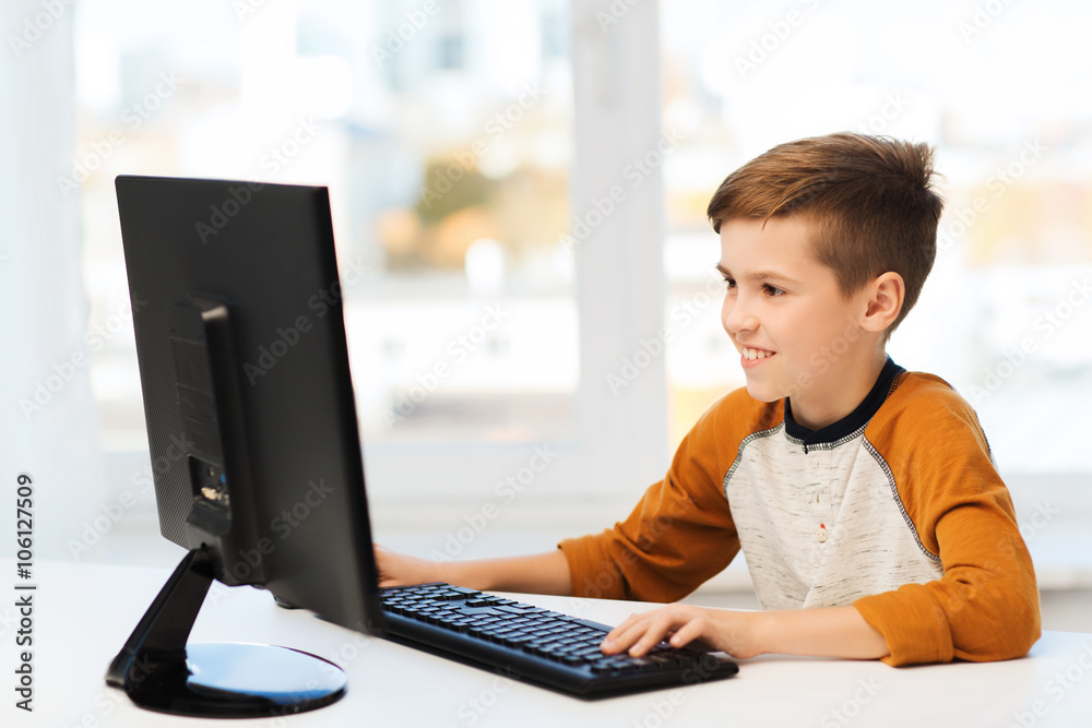 smiling boy with computer at home