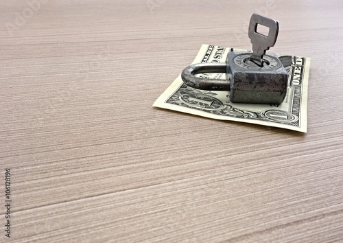 one dollar banknote and padlock on the table