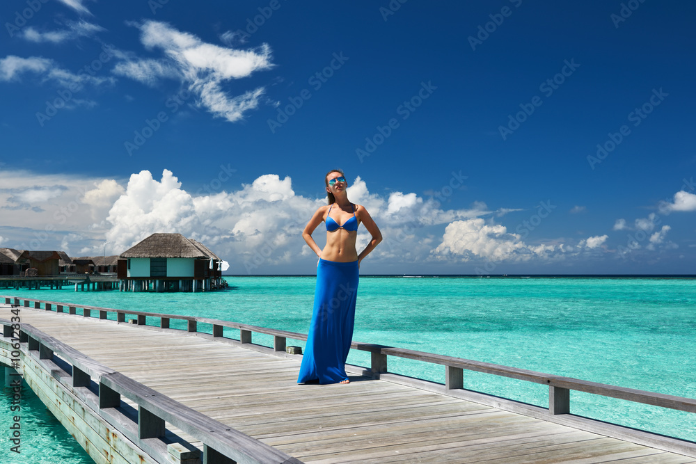 Woman on a beach jetty at Maldives Woman on a beach jetty at Maldives