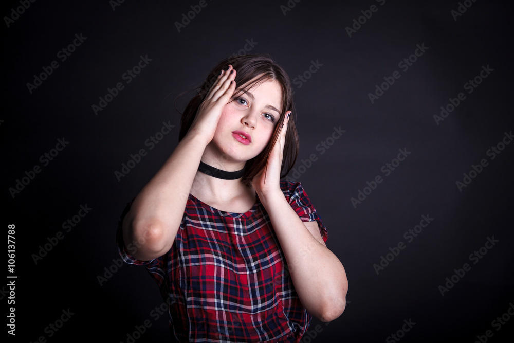 teen girl in a checkered dress posing on a dark background teen girl in a checkered dress posing on a dark background