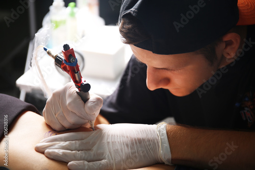 Tattooist makes tattoo, clo...