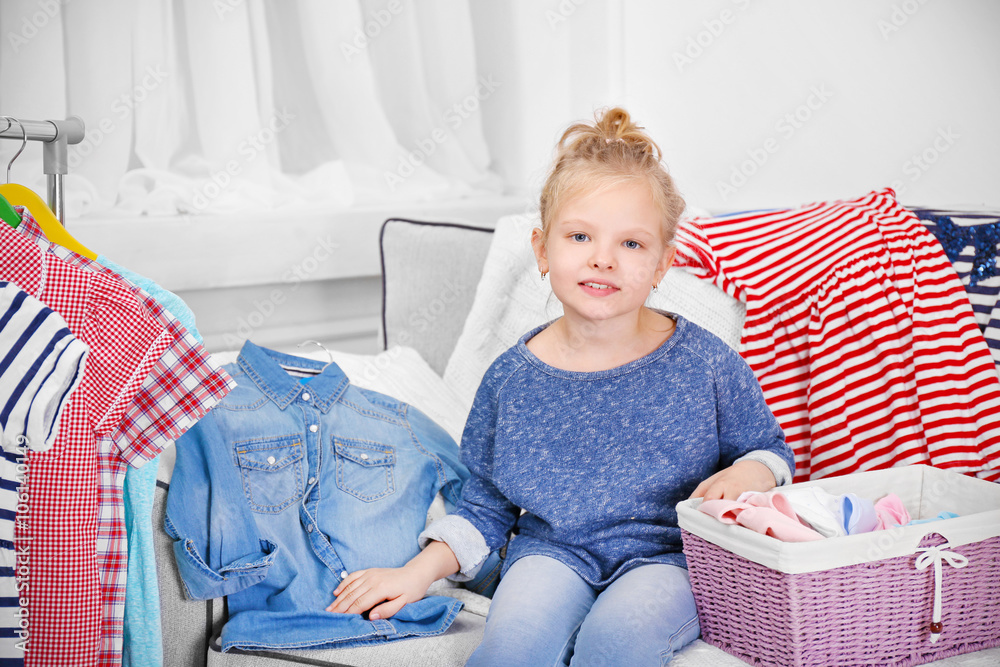 Little girl in the room with a lot of new clothes Little girl in the room with a lot of new clothes
