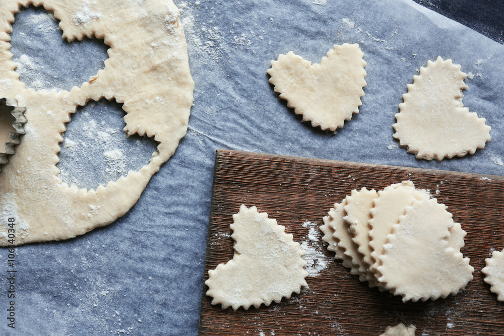 Uncooked heart shaped biscuits on a table