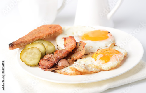 fried eggs with bacon and toasts on white background

