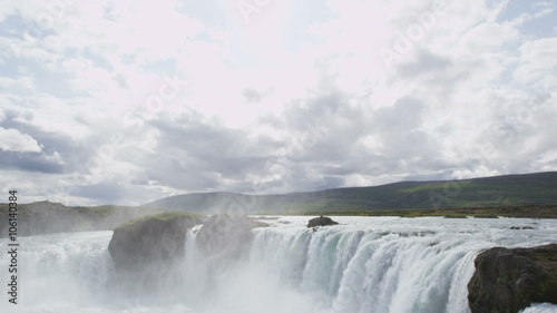 Iceland landscape scenic view of Godafoss waterfall against cloudy sky. It is one of the famous tourist attractions. It is a spectacular Icelandic waterfall on the North of island. photo