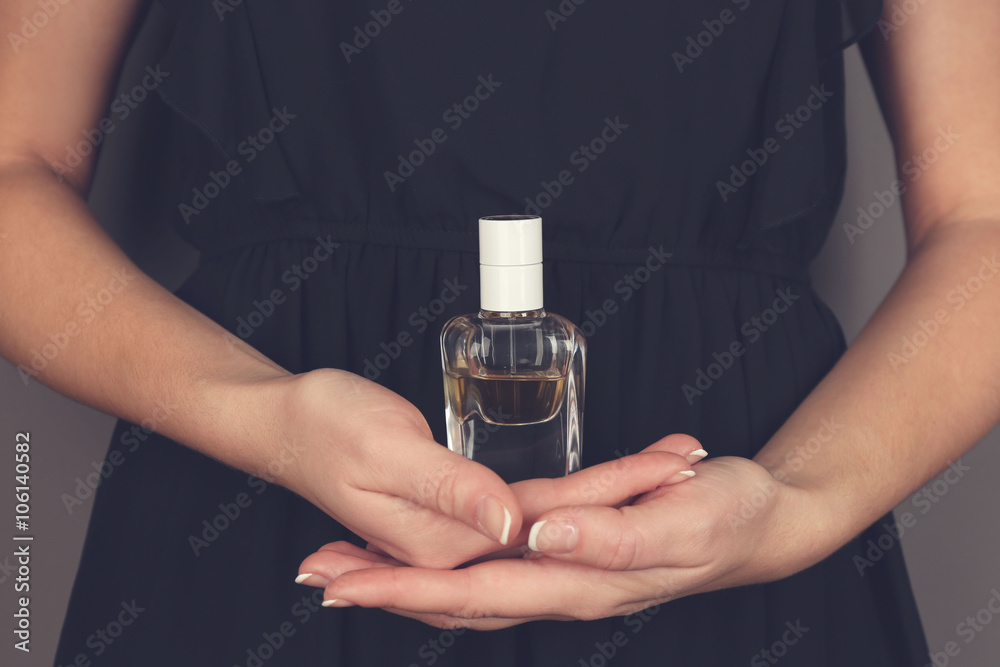 Fototapeta premium Young woman holding bottle perfume