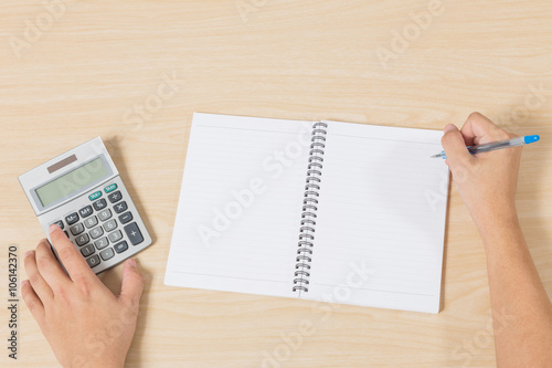 hand press calculator and writting on notebook