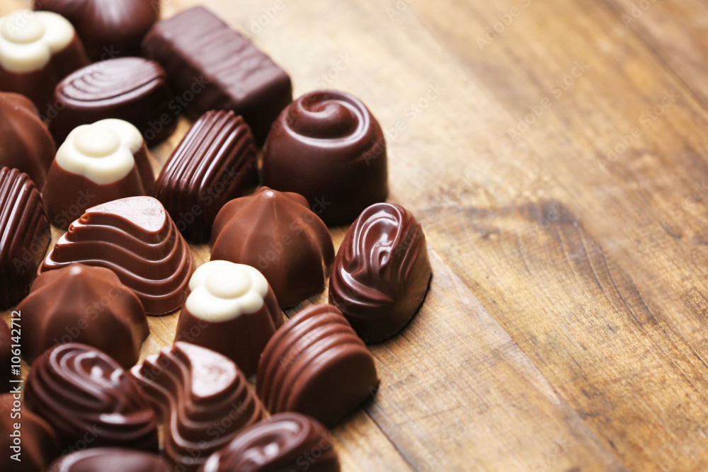 Delicious chocolate candies on wooden background Delicious chocolate candies on wooden background