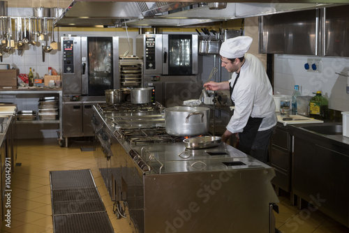 chefs cook and move around in the restaurant kitchen