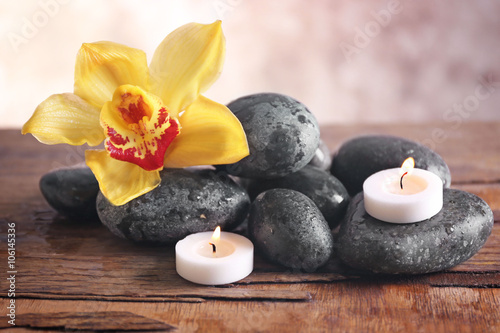 Spa still life with stones  flower and candlelight on blurred pastel background