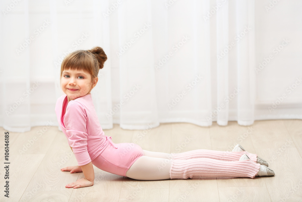 Little cute girl in pink leotard making new ballet movement at dance studio Little cute girl in pink leotard making new ballet movement at dance studio
