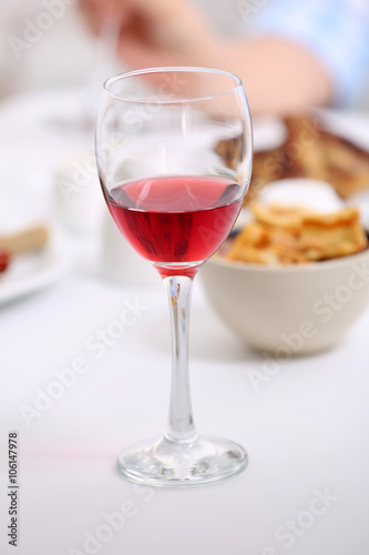Dinner with glass of wine on table closeup
