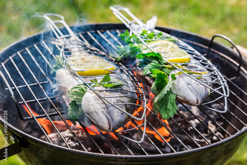 Grilling tasty fish with herbs and lemon