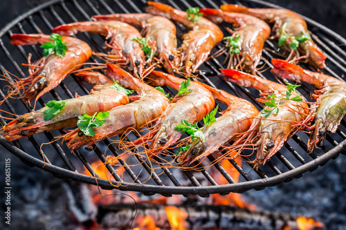 Big shrimps with lemon and parsley on hot grill