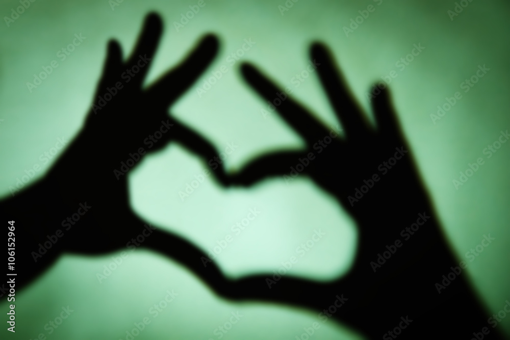 Fototapeta premium Hand shaped heart on green background