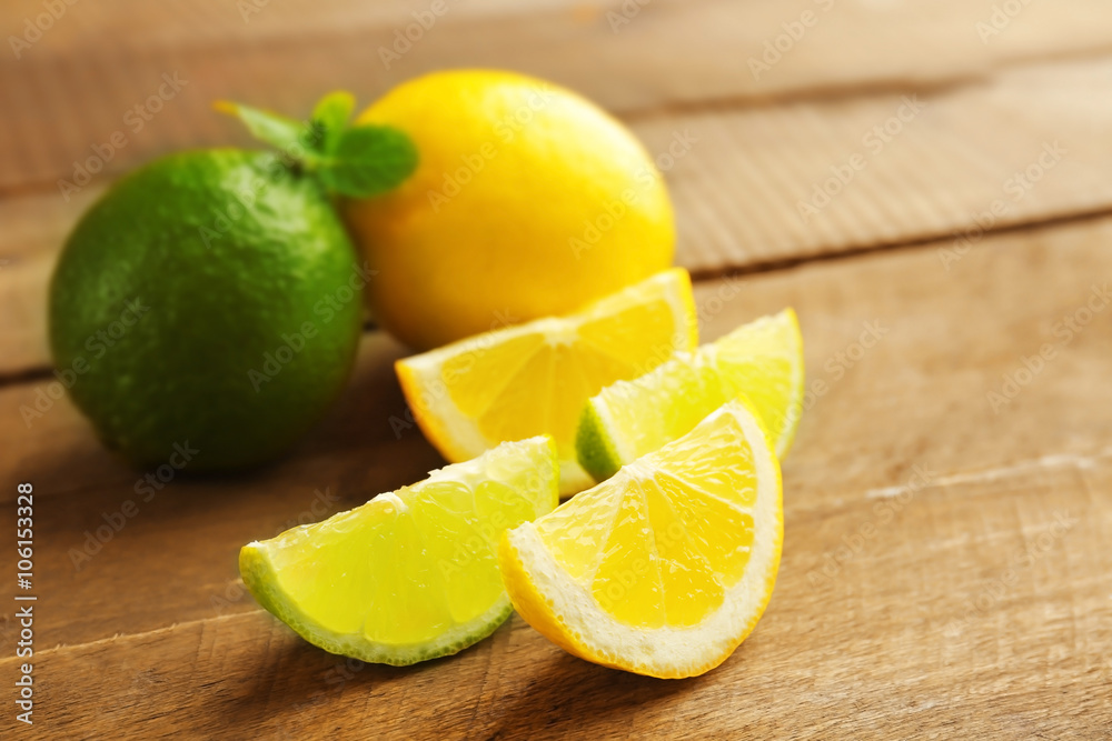 Sliced fresh lemon and lime on wooden table closeup
