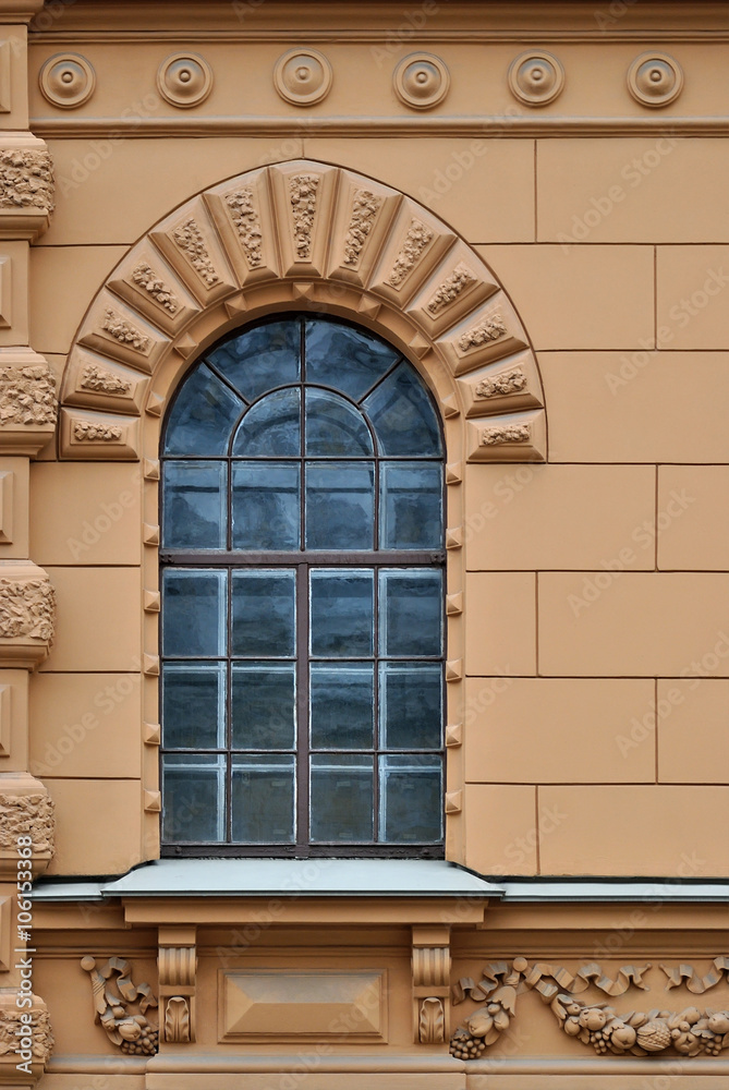 Window with arch and a bas-relief on a background of beige wall. From the series window of Saint-Petersburg.