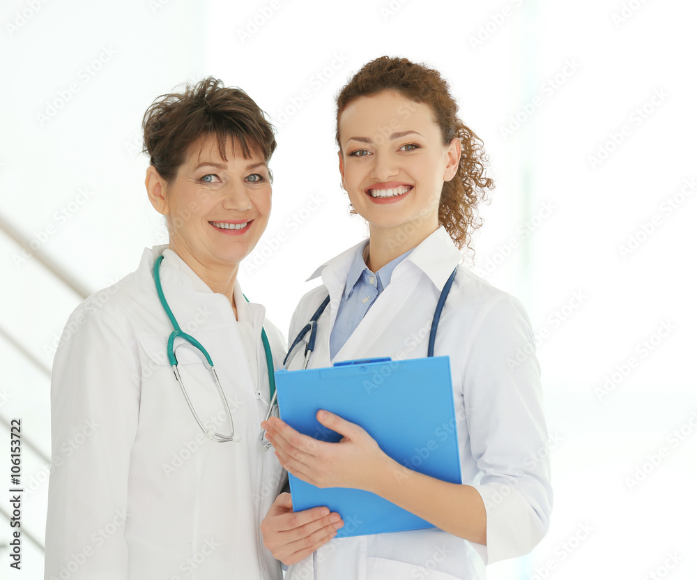 Portrait of two smiling female doctors indoors Portrait of two smiling female doctors indoors