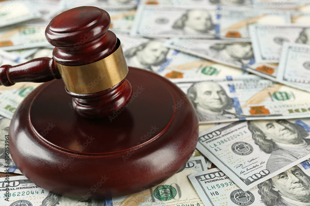 Law gavel on dollars background, closeup