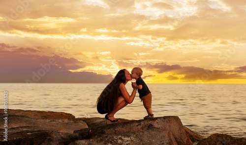 Mother and baby on the beach after sunset