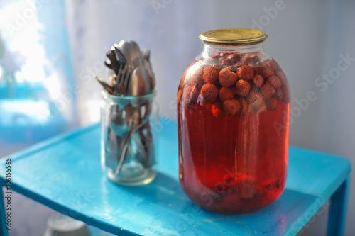 Tableau sur toile three-liter glass jar with strawberry compote canned on blue tab