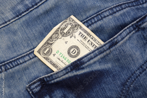 one dollar sticking out of a pocket of jeans