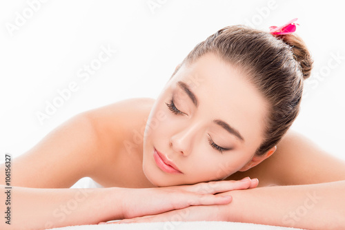 Portrait of calm pretty young woman laying in spa salon with clo