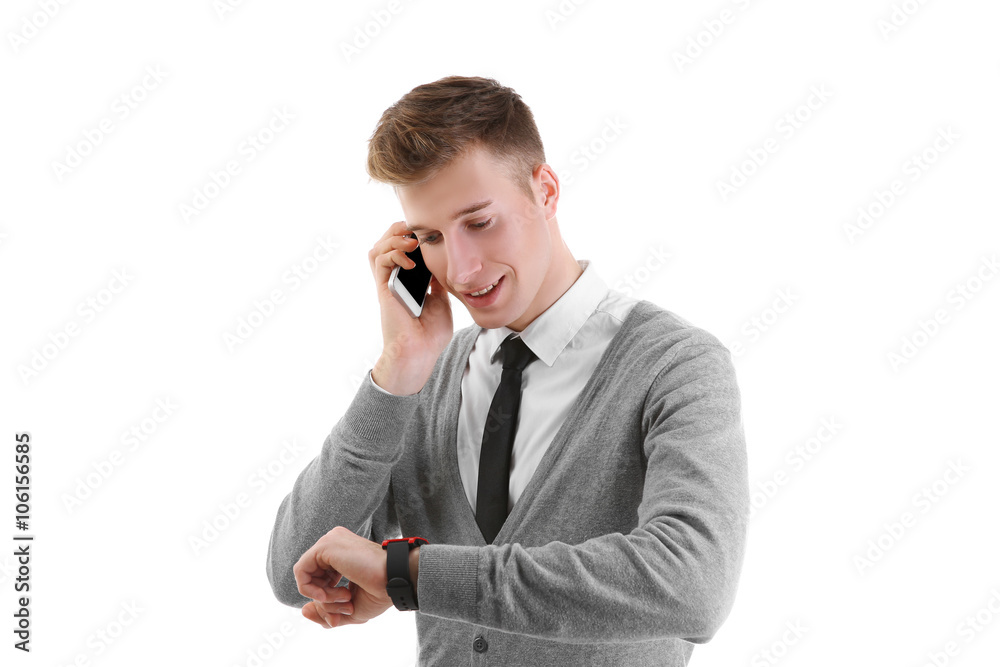 Young handsome man looking at his watch and using cellphone, isolated on white Young handsome man looking at his watch and using cellphone, isolated on white