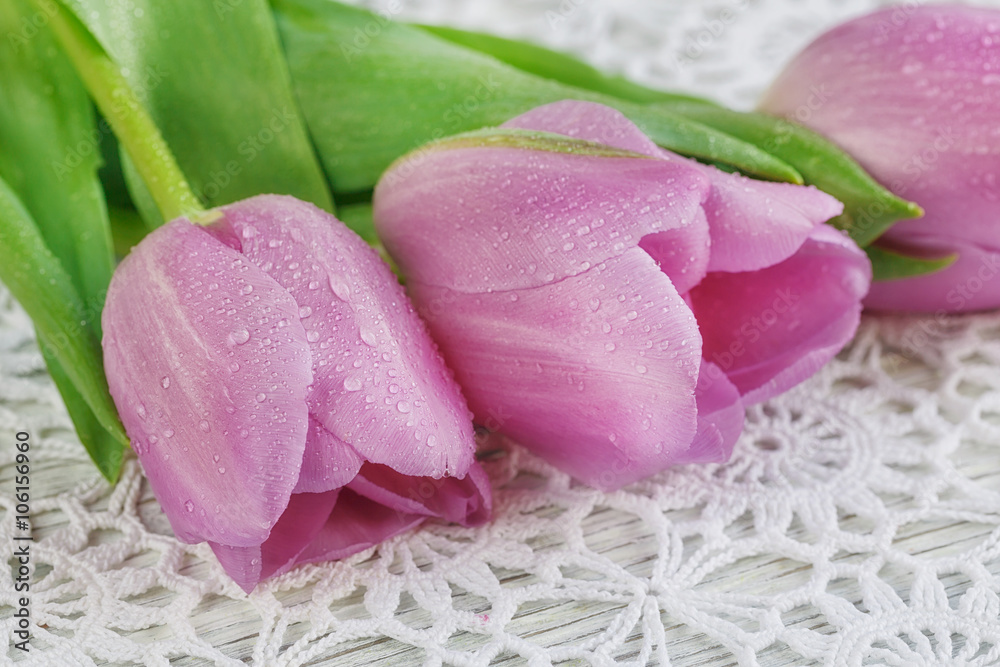Purple tulips on a beautiful crochet tablecloth