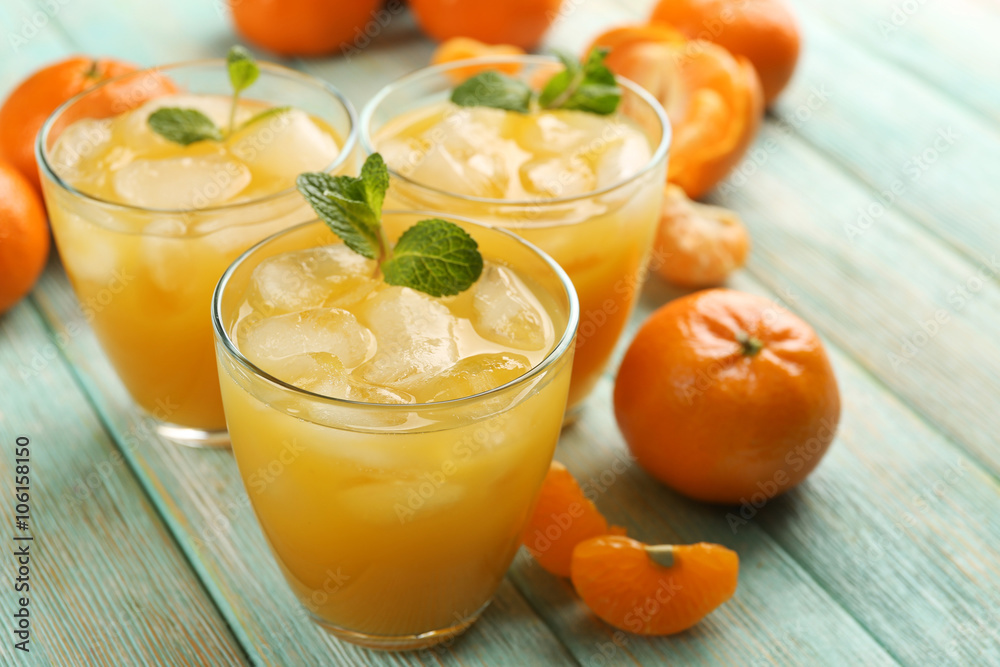 Fresh cocktails with ice, mint and tangerines on the wooden table, close up Fresh cocktails with ice, mint and tangerines on the wooden table, close up