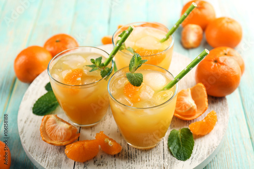 Fresh cocktails with ice, mint and tangerines on a white wooden board, close up