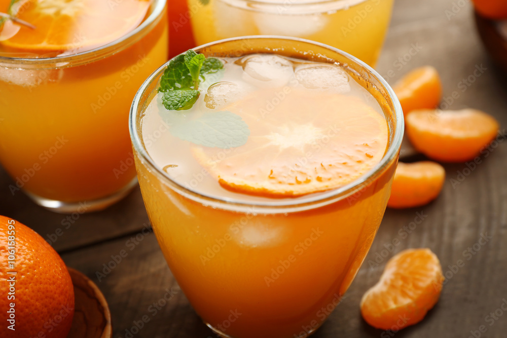 Tangerine cocktails with ice and mint on a wooden board, close up Tangerine cocktails with ice and mint on a wooden board, close up
