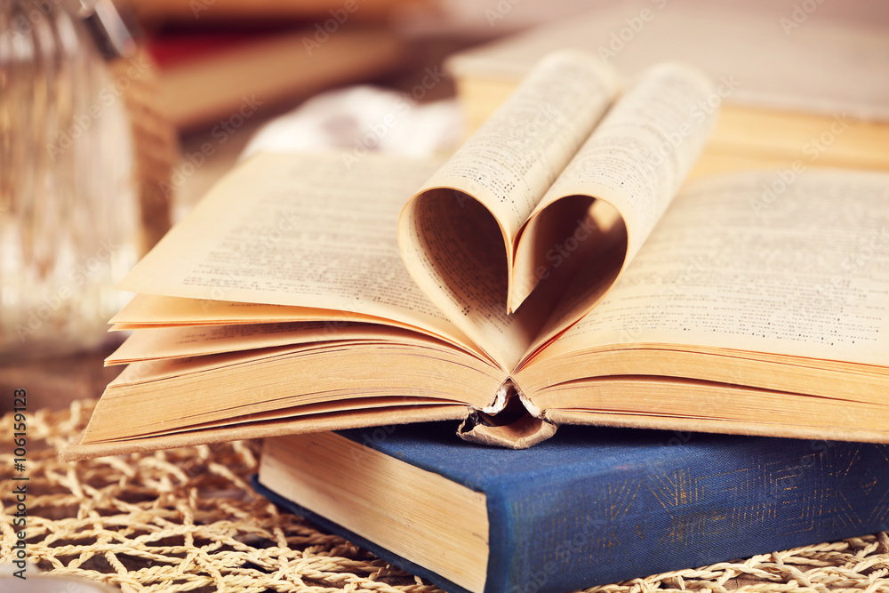 Naklejka premium Heart from book page on wicker background