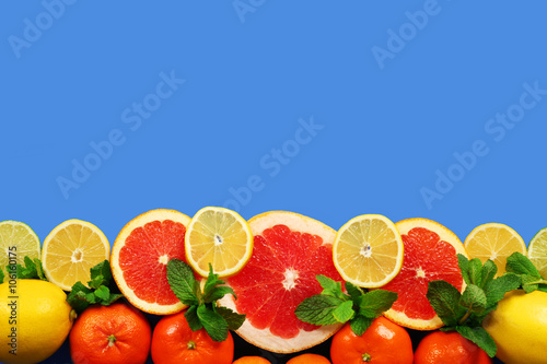 Fototapeta Naklejka Na Ścianę i Meble -  Set of sliced citrus fruit on blue background