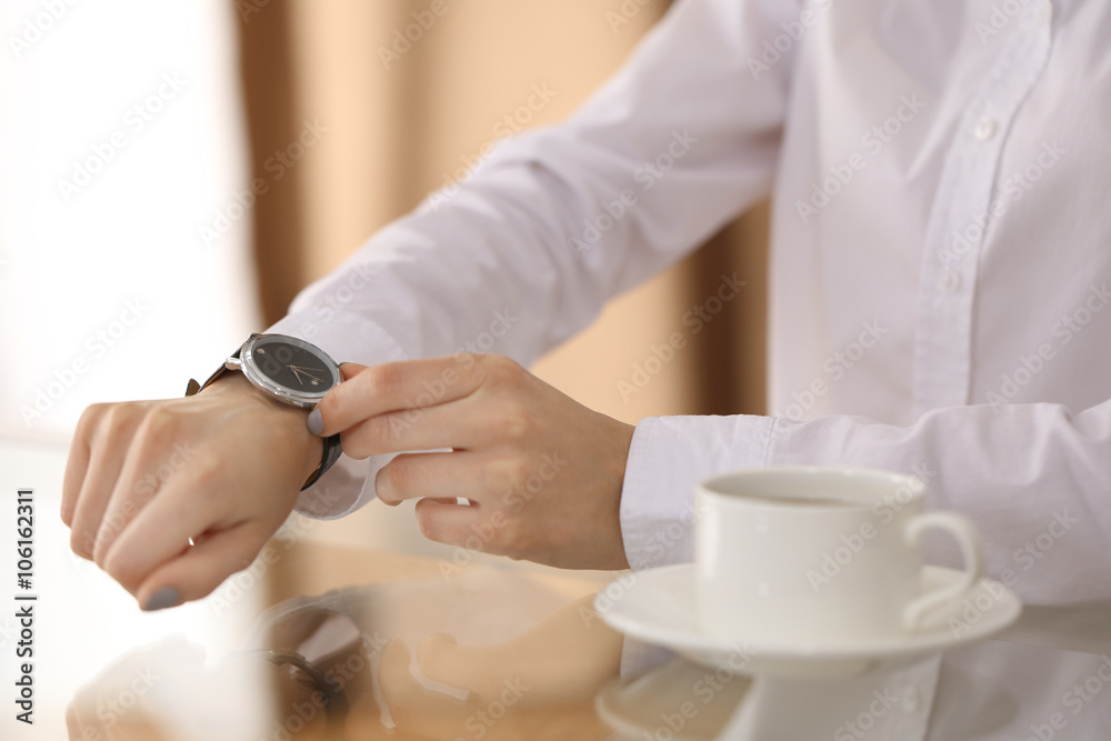 Businesswoman checking the time on her wrist watch, close up