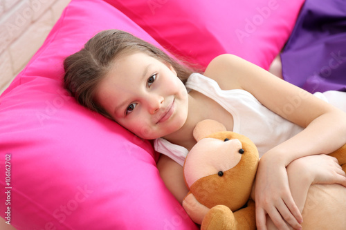 Little girl and toy bear in...