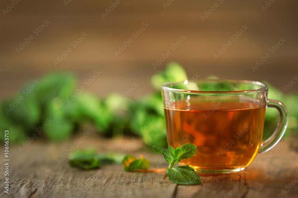 Cup of tea with mint on wooden table Cup of tea with mint on wooden table