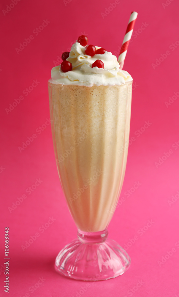 Glass of milk cocktail with cream and berries on pink background Glass of milk cocktail with cream and berries on pink background