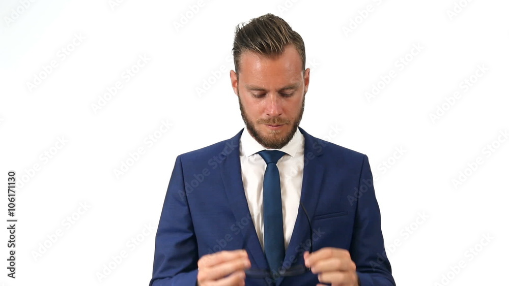 A mature businessman wearing a blue suit, blue tie and white shirt with glasses. Standing in front of a white background. A mature businessman wearing a blue suit, blue tie and white shirt with glasses. Standing in front of a white background.