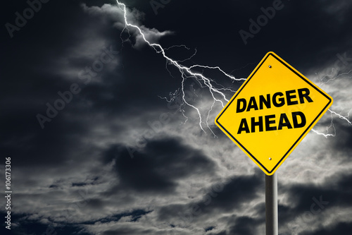 Fototapeta Danger Ahead Sign Against Cloudy and Thunderous Sky